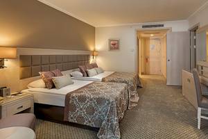 Doppelzimmer im Miracle Resort mit zwei Betten, Schreibtisch und Fernseher.