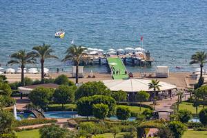 Wunderschoenes Resort am Meer mit Booten und Palmen