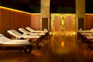Buddha-Meditationsraum im Miracle Resort mit goldenem Buddha-Bild und gedämpften Lichtern auf Lounge-Liegestühlen