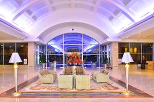 Ein Hotel-Foyer mit einem Blumenarrangement auf einem Tisch und umgeben von gepolsterten Sesseln.