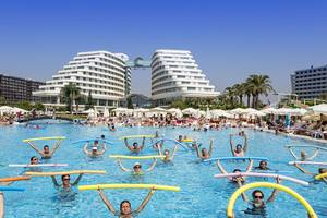 Gruppe von Leuten, die Aqua-Fitness im Miracle Resort machen, mit bunten Schwimmhilfen.