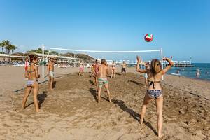 Volleyballspiel am Strand des Miracle Resorts mit Teilnehmern und einem Ball in der Luft.