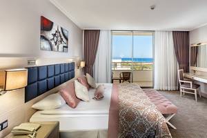 Zimmer im Miracle Resort mit Blick auf das Meer und Balkon.