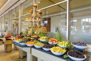 Wunderschönes Frühstücksbuffet im Miracle Resort mit einer Vielzahl von Obst in weißen Schalen.