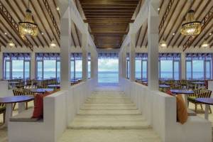 Innenbereich des OBLU Nature Helengeli Restaurants mit Blick auf das Meer und mehreren Tischen und Stühlen.