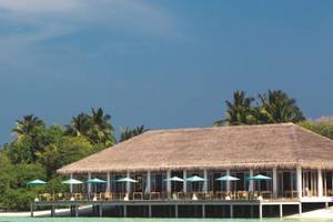 Außenbereich des Oblu Nature Hengeli Resorts mit vielen Tischen und Stühlen unter Sonnenschirmen.
