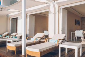 Loungebereich im Coral Level at Iberostar Selection Cancun mit weißen Liegestühlen und Tischen.