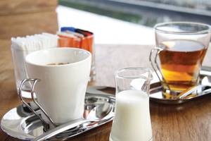 Ein Bild von zwei Tassen Kaffee und Milch auf einem Holztisch.
