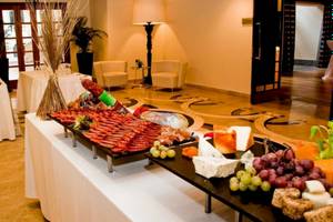 Buffettisch im AX The Palace mit verschiedenen Gerichten wie Schinken, Käse und Obst.