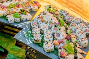 Sushi-Buffet im AX The Palace Hotel mit verschiedenen Sushi-Rollen auf schwarzen Platten.