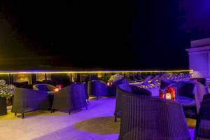 Terrasse des AX The Palace Hotels bei Nacht mit blauer Beleuchtung und gemütlichen Sitzgelegenheiten.