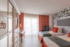 Doppelzimmer im AX The Palace Hotel mit zwei Betten, einem Schreibtisch, einem Stuhl und einem Fenster.