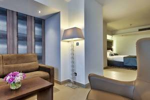 Innenansicht des AX The Palace Hotels mit Sofa, Tisch, Lampe und Schlafzimmer