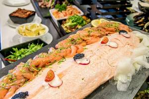 Buffet-Tisch im AX The Palace Hotel mit verschiedenen Gerichten, einschließlich Lachs und Beilagen.