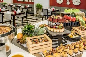Buffet im Restaurant des AX The Palace Hotels mit verschiedenen Desserts und Früchten.