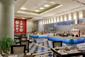 Innenansicht des Restaurants im AX The Palace Hotel mit Frühstücksbuffet, Tischen und Stühlen.