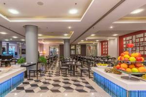 Frühstücksbuffet im AX The Palace Hotel mit Obst, Gemüse und verschiedenen Gerichten.