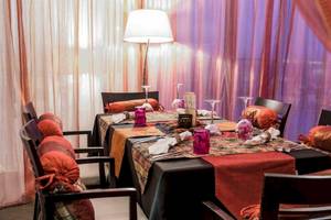 Das Esszimmer im AX The Palace Hotel mit Tisch, Stühlen und Tischdekoration.