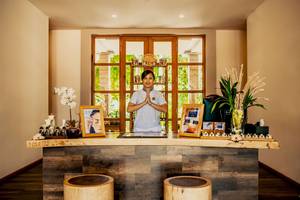 Empfang des Kudafushi Resort & Spa mit einer Frau, die vor einem Schreibtisch steht