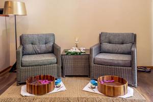 Massagebereich im Kudafushi Resort & Spa mit zwei Sessel und Wasserschalen.