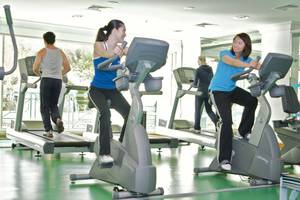 Fitnesscenter im Al Raha Beach Hotel mit Personen auf Trainingsfahrrädern