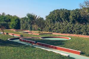 Golfplatz im Freien im Iberostar Mehari Djerba Hotel, umgeben von Bäumen und grünem Rasen.