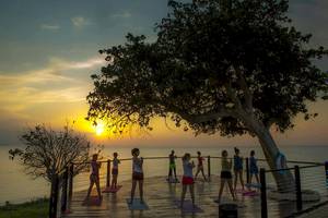 Yoga-Übung am Strand im Royal Zanzibar Beach Resort bei Sonnenuntergang.