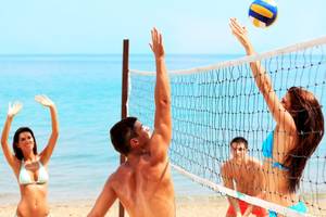 Volleyballspiel am Strand im Royal Zanzibar Beach Resort mit Spielern und Ball über dem Netz.