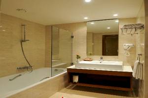 Ein Badezimmer mit Badewanne, Waschbecken und Spiegel im Vincci Helios Beach Hotel.