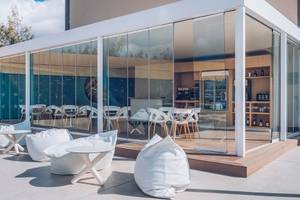 Außenbereich des Iberostar Selection Fuerteventura Palace mit großen Glaswänden und weißen Möbeln.