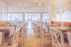 Innenansicht des Restaurants im Iberostar Selection Fuerteventura Palace Hotel mit weißen Tischen und Stühlen.