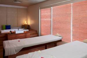 Behandlungsraum im Jetwing Blue Spa mit zwei Massageliegen und einem Badewannenbereich.