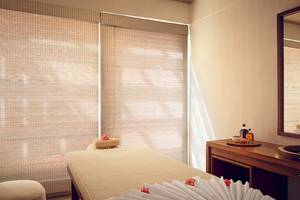 Spa-Behandlungsraum im Jetwing Blue Hotel mit Bambusrollos und Massagetisch.