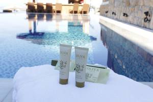 Pool am Almira Hotel mit Olivenpflegeprodukten auf einem Handtuch.