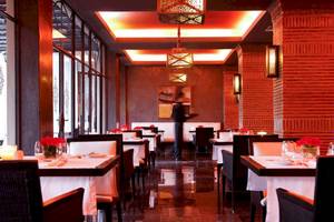 Innenansicht des Sofitel Marrakech Lounge & Spa Restaurants mit roten Leuchten und gedeckten Tischen.