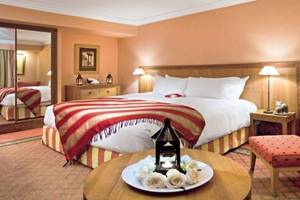 Hotelzimmer im Sofitel Marrakech Lounge & Spa mit Bett, Tisch, Rosen und Lampe