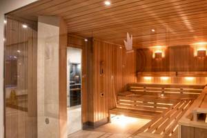 Innenansicht der Sauna im Guayarmina Princess Hotel mit Holzbänken und warmem Licht.