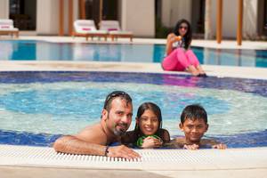 Familie im Pool im Sifawy Boutique Hotel mit einer Frau am Rand