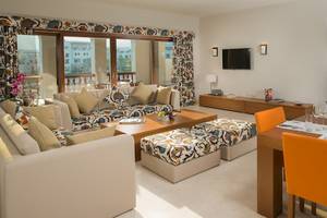 Das Wohnzimmer des Sifawy Boutique Hotels mit Couch, Esstisch und Fernseher.