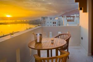 Balkon des Sifawy Boutique Hotels mit Blick auf den Sonnenuntergang über dem Meer.
