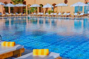Pool-Loungebereich im Chedi El Gouna Hotel mit Sonnenliegen und Sonnenschirmen