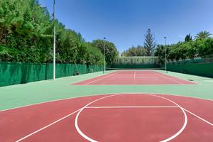 Tennisplatz des Bull Costa Canaria & Spa Hotels mit roten Belägen und grünen Zäunen.