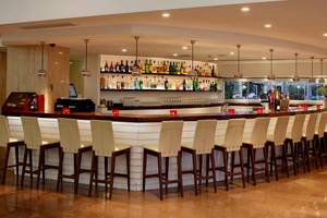 Die Bar im Sunrise Beach Hotel in Zypern mit vielen Sitzgelegenheiten und einer gut bestückten Bar.