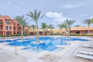Außenbereich des JAZ Neo Dar El Madina Hotels mit Swimmingpool und Liegestühlen