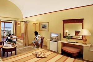 Hotelzimmer im Jaz Dar El Madina mit Familie, Fernseher, Spiegel und Fenster mit Meerblick.