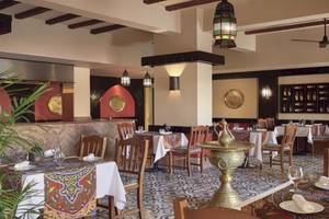 Innenansicht des Restaurants im Hotel JAZ Neo Dar El Madina mit gedeckten Tischen und Stühlen.