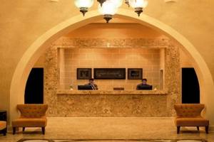 Reception im Jaz Neo Dar El Madina Hotel mit zwei Angestellten und modernen Möbeln.