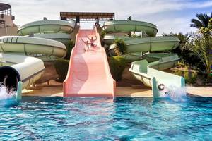 Wasserrutschen im Jaz Dar El Madina Hotel mit Personen, die die Rutschen hinuntergleiten.