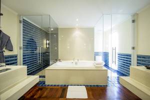 Badezimmer im Robinson Khao Lak Hotel mit Badewanne und blauen Fliesen.