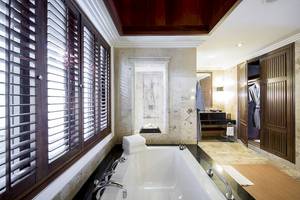 Badezimmer im Robinson Khao Lak Hotel mit Badewanne, Dusche und Holzelementen.